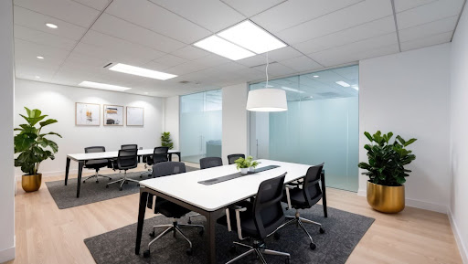 Salle de réunion moderne avec finition intérieure durable adaptée aux immeubles à bureaux — murs blancs, plancher de bois clair, mobilier ergonomique et végétation intégrée.